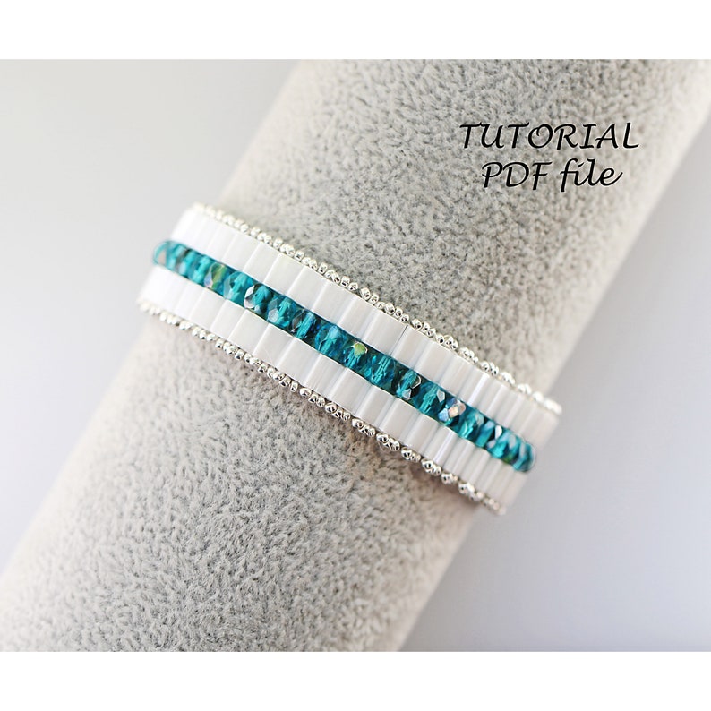 May include: A white and turquoise beaded bracelet with a silver thread running through the beads. The bracelet is displayed on a gray fabric surface. The text "TUTORIAL PDF file" is visible in the upper right corner of the image.