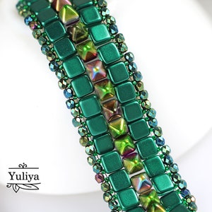 May include: A green and iridescent beaded bracelet with a geometric pattern. The bracelet is made with square and triangular beads.
