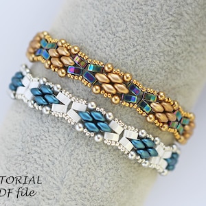 Op de afbeelding: Twee kralenarmbanden, een met gouden en regenboogkleurige blauwe kralen, de andere met zilveren en blauwgroene kralen. De armbanden liggen op een grijze achtergrond met de tekst "TUTORIAL PDF file".