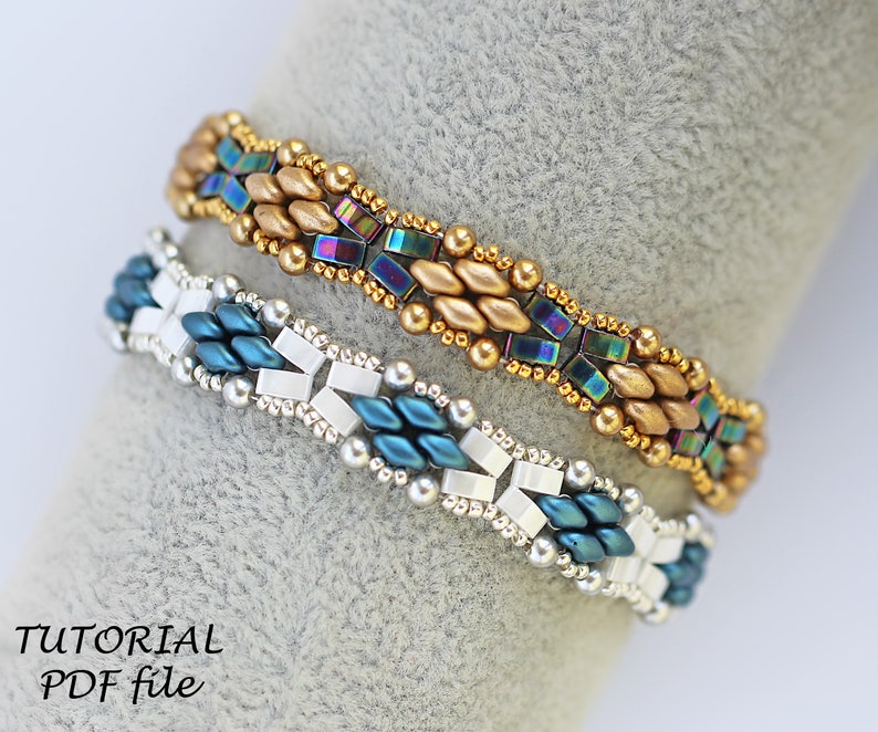 Op de afbeelding: Twee kralenarmbanden, een met gouden en regenboogkleurige blauwe kralen, de andere met zilveren en blauwgroene kralen. De armbanden liggen op een grijze achtergrond met de tekst "TUTORIAL PDF file".