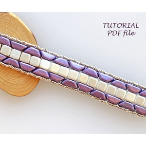 Peut inclure: Un bracelet en perles de couleur violette et blanche avec un fil argenté qui le traverse. Le bracelet est composé de petites perles carrées et triangulaires. L'image comprend le texte "TUTORIAL PDF file".