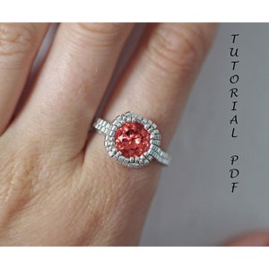 May include: A silver beaded ring with a large, round, red gemstone in the center.