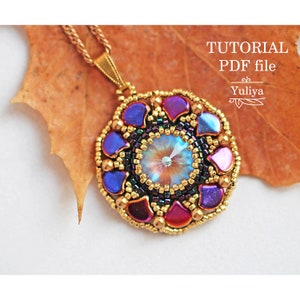 May include: A gold chain necklace with a beaded pendant featuring a central iridescent crystal surrounded by purple, blue, and red beads. The pendant is on a brown leaf. The text "TUTORIAL PDF file Yuliya" is in the upper right corner of the image.