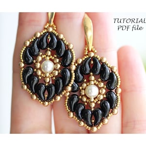 May include: A pair of gold and black beaded earrings with a pearl accent. The earrings are in the shape of a flower with a circular center.