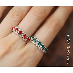 Könnte beinhalten: Zwei silberne Ringe mit roten und grünen Edelsteinen. Die Ringe befinden sich an einem Finger.