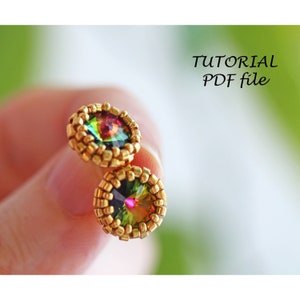 Op de afbeelding: Een paar gouden oorbellen met regenboogkleurige ronde stenen die in een kralenframe zijn gezet. De oorbellen worden in een hand gehouden, tegen een groene achtergrond met de tekst "TUTORIAL PDF file".