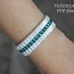 May include: A white and teal beaded bracelet with silver accents.  The bracelet is on a person's wrist.  The image includes the text "TUTORIAL PDF file".