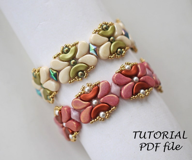 Op de afbeelding: Twee kralenarmbanden met een bloemenpatroon. De bovenste armband is wit met groene accenten en de onderste armband is roze met oranje accenten. De armbanden liggen op een wit oppervlak met de tekst "TUTORIAL PDF file".