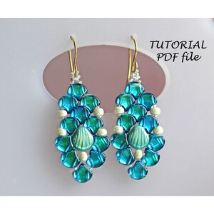 May include: A pair of teal blue and white beaded earrings with a seashell design. The earrings are hanging from gold hooks. The image includes the text "TUTORIAL PDF file".