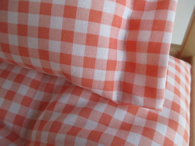 May include: Two orange and white gingham pillowcases. The pillowcases are made of a soft, cotton fabric and have a subtle sheen.