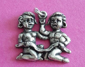 May include: Silver charm depicting the Gemini zodiac sign, featuring two figures of twins holding a ribbon.