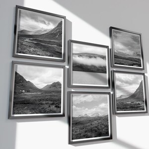 May include: A collection of six framed black and white landscape photographs. The images depict mountain ranges, valleys, and cloudy skies. The frames are dark gray, and the arrangement is displayed on a white wall.