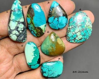 May include: Seven polished turquoise cabochons labeled 1 through 7, displaying various shades of blue and green with dark matrix patterns. The stones range in shape from teardrop to oval and rectangular, with a size range of 34-21mm indicated.