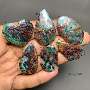 May include: Six polished gemstones labeled 1 through 6, featuring a mix of green, brown, and white patterns with metallic inclusions. The stones are shaped as hearts, teardrops, and ovals, with a size range indicated as 36-29mm on the image.
