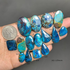 Puede incluir: Una colección de quince piedras preciosas pulidas de diversas formas, incluyendo ovaladas, en forma de lágrima y rectangulares. Las piedras muestran una mezcla de tonos azules, turquesas y marrones. Se incluye una moneda como referencia de tamaño. Las piedras preciosas miden de 1,5 cm a 3,2 cm.
