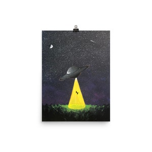 May include: A black UFO with a bright yellow light shining down on a dark green field against a starry night sky.