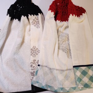 May include: Two white kitchen towels with a crocheted top. One towel has a black crocheted top and the other has a red crocheted top. Both towels have a patterned design and a plaid trim.