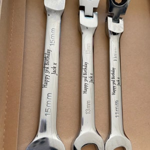 May include: Three silver, adjustable spanners with the text "Happy 3rd Birthday Jack x" and size markings of 15mm, 13mm, and 11mm. The spanners are in a cardboard box.