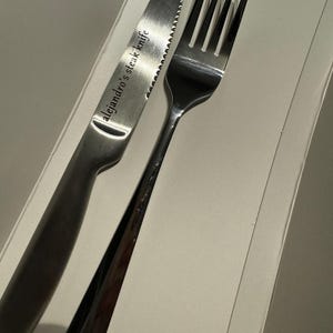 以下が含まれることがあります： 「alejandro's steak knife」と刻まれた銀のステーキナイフと銀のフォーク