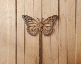 May include: A rusty metal butterfly garden stake with a decorative cutout design. The stake is brown and has a rustic look.