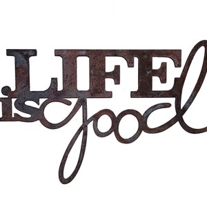 May include: Rustic metal wall decor with the words "Life is good" in a distressed brown finish.