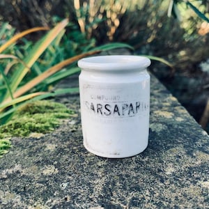 May include: White ceramic jar with black lettering that reads "Compound Syrup Sarsaparilla".