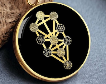 May include: A gold necklace with a black round pendant featuring a gold geometric tree of life design.