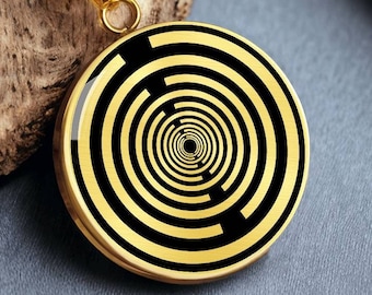 May include: A gold chain necklace with a round pendant featuring a black and gold concentric circle design.