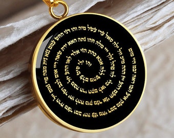 May include: A gold chain necklace with a round pendant. The pendant is black with gold Hebrew writing in a spiral pattern.