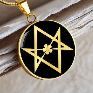 May include: Gold chain necklace with a black round pendant featuring a gold five-pointed star with a four-leaf clover in the center.