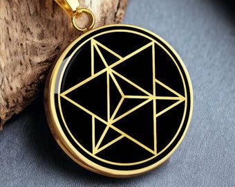 May include: A gold chain necklace with a round pendant featuring a black background and a gold geometric star design.