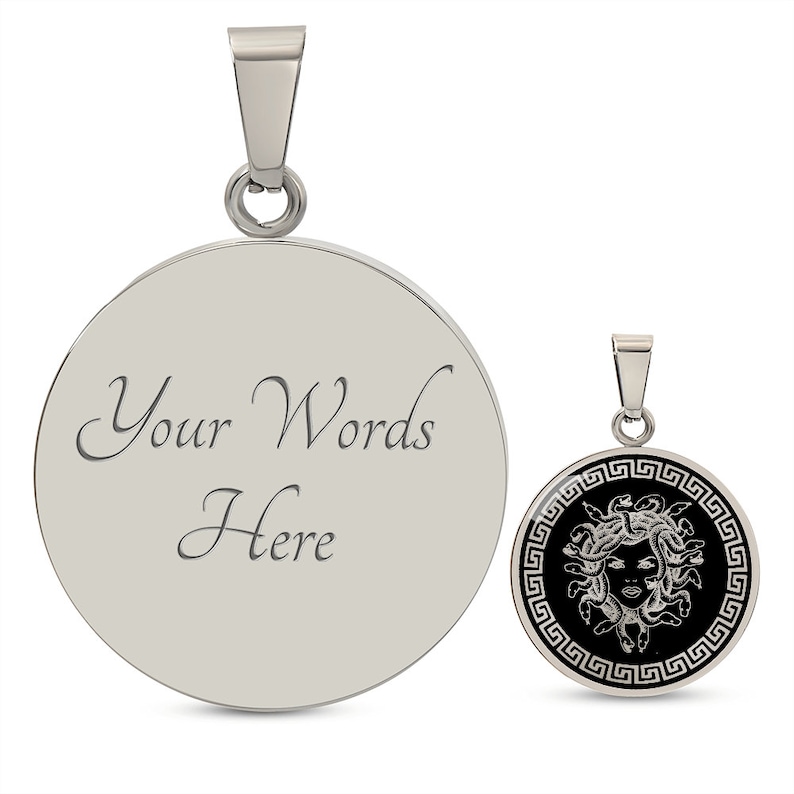 May include: A silver pendant with a round, black enamel face featuring a Medusa head with snakes and a Greek key border. The back of the pendant is blank and can be engraved with "Your Words Here".