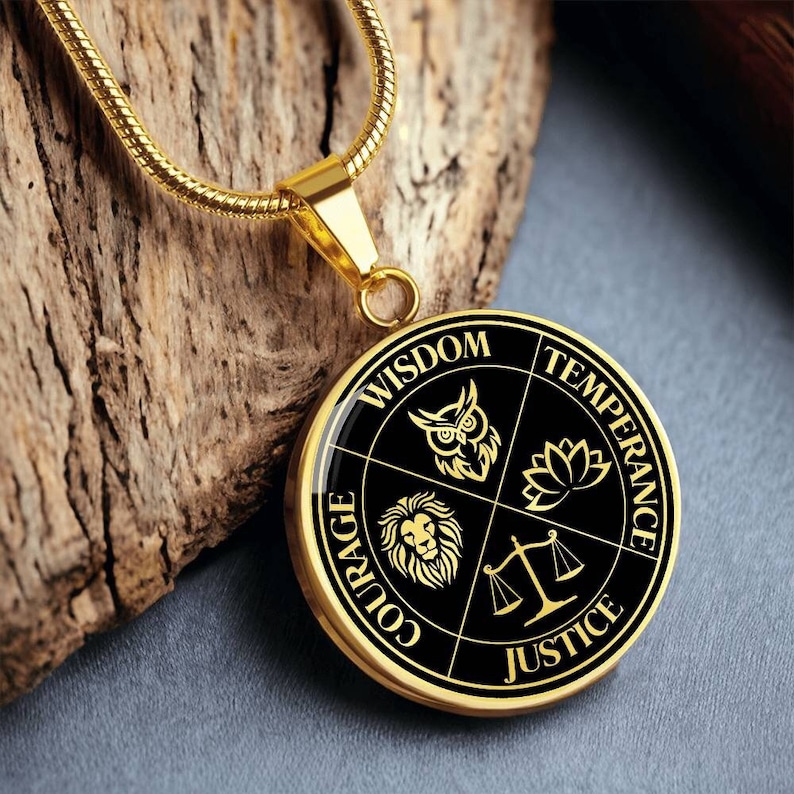 Op de afbeelding: Gouden ketting met een ronde hanger met vier zwarte symbolen die wijsheid, matigheid, moed en rechtvaardigheid voorstellen. De hanger heeft een zwarte achtergrond met gouden letters en symbolen.