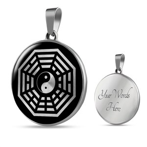 Puede incluir: Un collar con un colgante de plata con un s&iacute;mbolo yin yang blanco y negro dentro de una estrella de ocho puntas plateada. La parte posterior del colgante est&aacute; en blanco y se puede grabar con texto. "Your Words Here" est&aacute; grabado en la parte posterior del colgante.