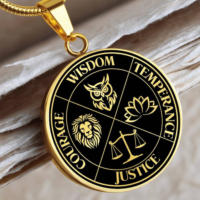 Op de afbeelding: Gouden ketting met een ronde hanger met vier zwarte kwadranten met gouden tekst en afbeeldingen. De kwadranten lezen "Wijsheid", "Matigheid", "Rechtvaardigheid" en "Moed". Elk kwadrant heeft een symbool: een uil, een lotusbloem, een weegschaal en een leeuw.