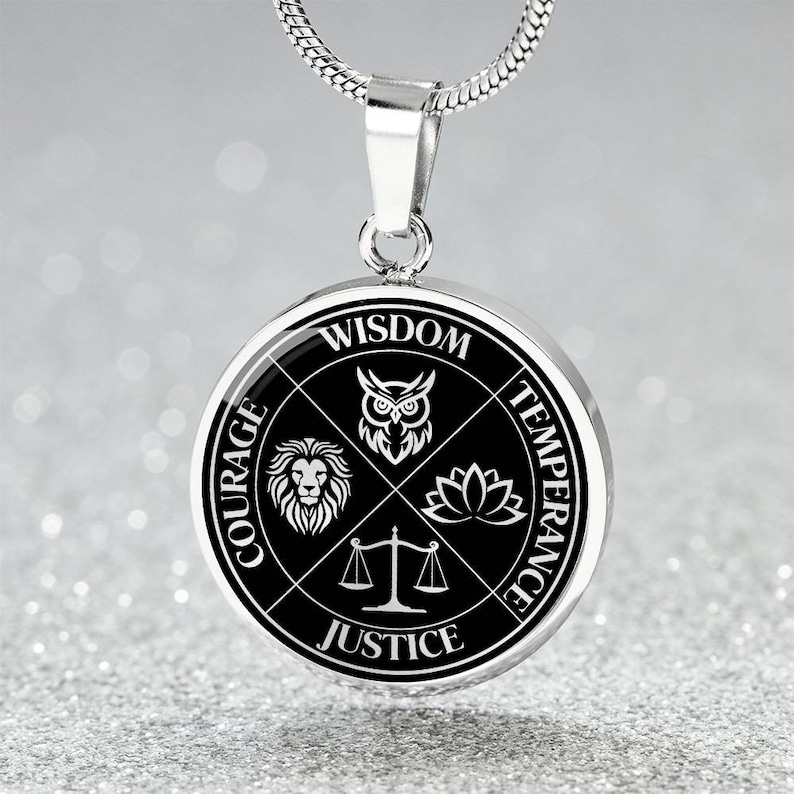 Op de afbeelding: Een zilveren ketting met een ronde hanger met vier symbolen die wijsheid, moed, matigheid en rechtvaardigheid voorstellen. De hanger is zwart met witte symbolen en tekst.
