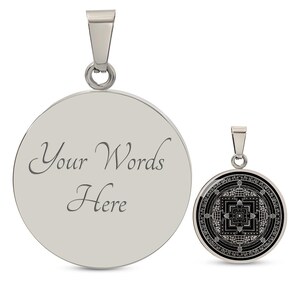May include: Two silver pendants, one with a blank circular surface and the text "Your Words Here" engraved on it, and the other with a black and white mandala design.
