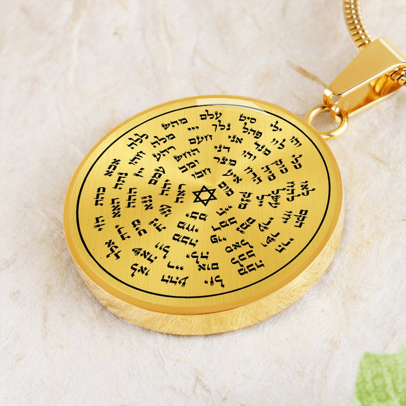 May include: A gold-toned pendant necklace with a round charm featuring a Star of David and Hebrew text. The charm is surrounded by a circle of Hebrew text.