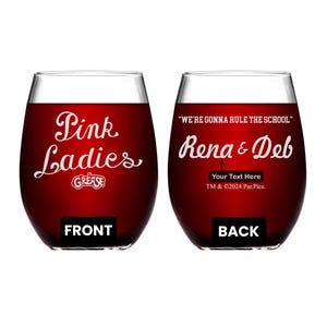 May include: Two red wine glasses with white text. The front glass says "Pink Ladies" with the word "Grease" underneath. The back glass says "We're gonna rule the school" and "Rena & Deb" with the text "Your Text Here" and "TM & ©2024 Par. Pics."