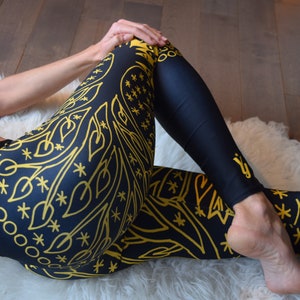 May include: Black leggings with a gold mandala pattern. The leggings are made of a stretchy, comfortable fabric and are perfect for yoga, running, or everyday wear.