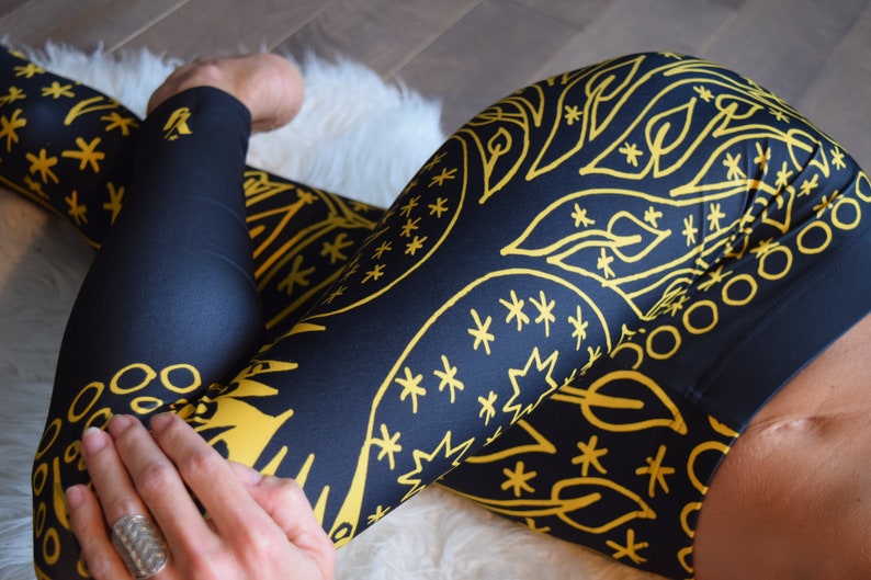 May include: Black leggings with a gold abstract pattern of stars, circles, and leaves.