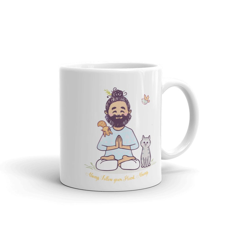 Puede incluir: Taza de cer&aacute;mica blanca con una ilustraci&oacute;n de dibujos animados de un hombre meditando con una ardilla y un gato. El texto "Always follow your heart - Always" est&aacute; impreso en la parte inferior de la taza.