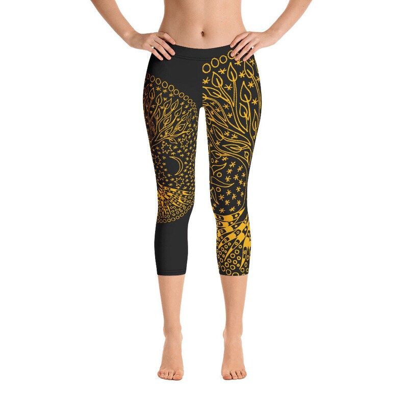 May include: Black yoga leggings with a gold tree of life design. The design features a tree with branches and leaves, a crescent moon, and stars.
