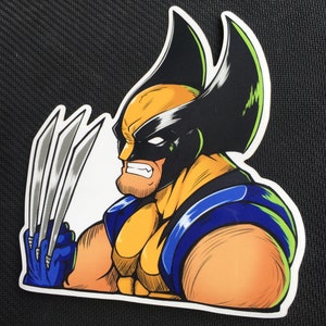 Peut inclure: Autocollant représentant Wolverine, un personnage de bande dessinée, de profil. L'illustration montre Wolverine avec ses griffes déployées. Le personnage porte un masque jaune et noir, un costume bleu et jaune et une expression déterminée.