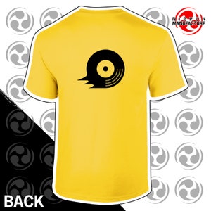 May include: Yellow t-shirt with a black graphic of a record with a tail flame. The text "NIPPON MANUFACTURE" is in the top right corner of the image.