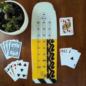 Planche de ski cribbage unique, livrée avec 9 piquets en métal et un jeu de cartes.