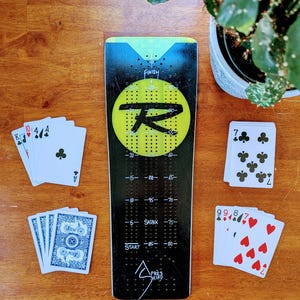 Planche de ski cribbage unique, livrée avec 9 piquets en métal et un jeu de cartes.