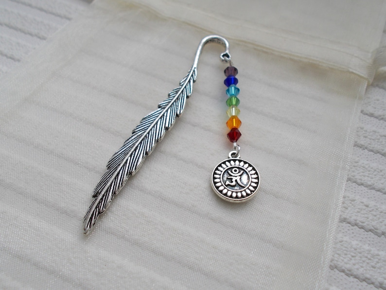 May include: Silver feather bookmark with a rainbow of crystal beads and a silver charm with the Om symbol.
