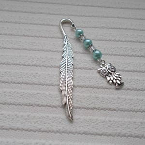 May include: Silver feather bookmark with a silver owl charm and light blue beads.