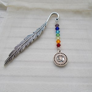 May include: Silver feather bookmark with a rainbow of crystal beads and a silver charm with an Om symbol.